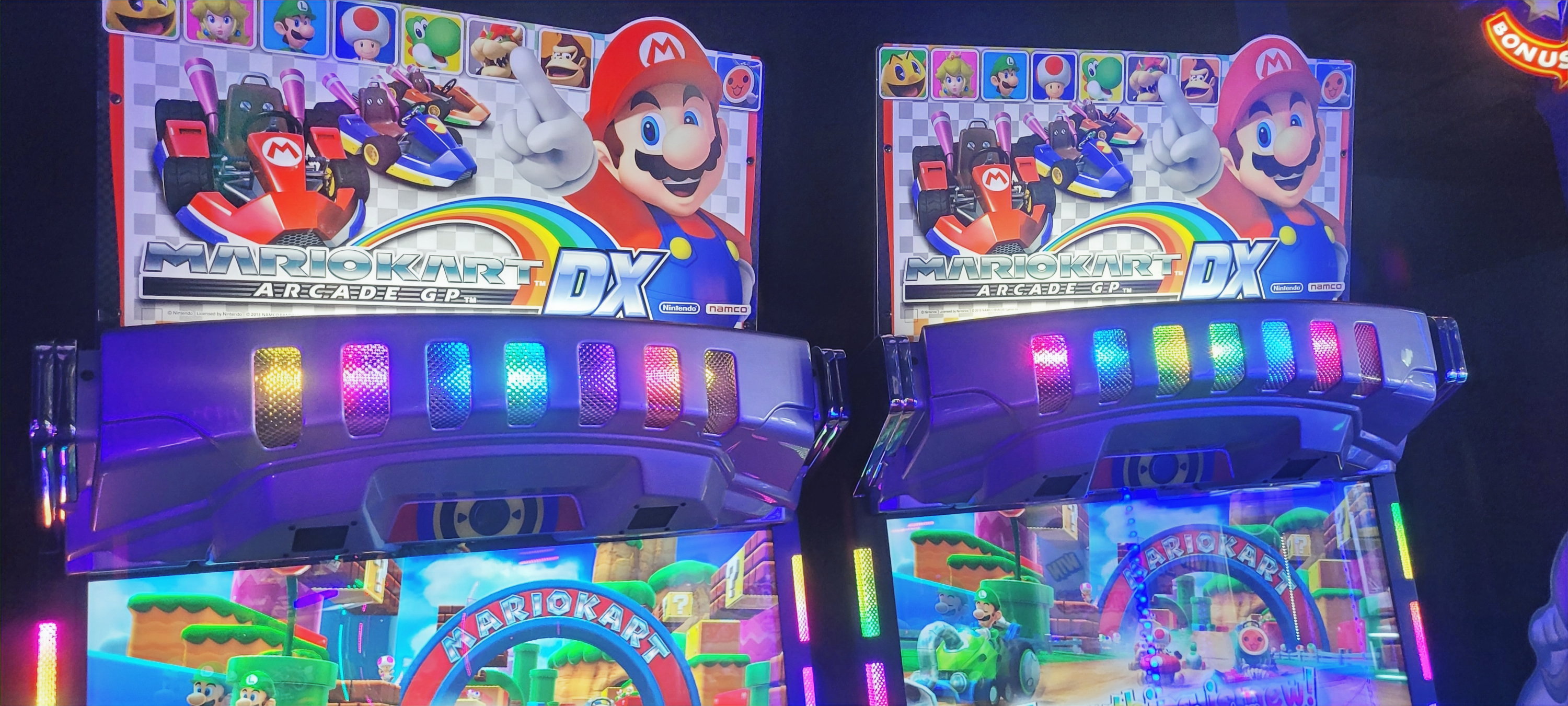 Mario Kart Arcade DX machines glowing with colorful lights