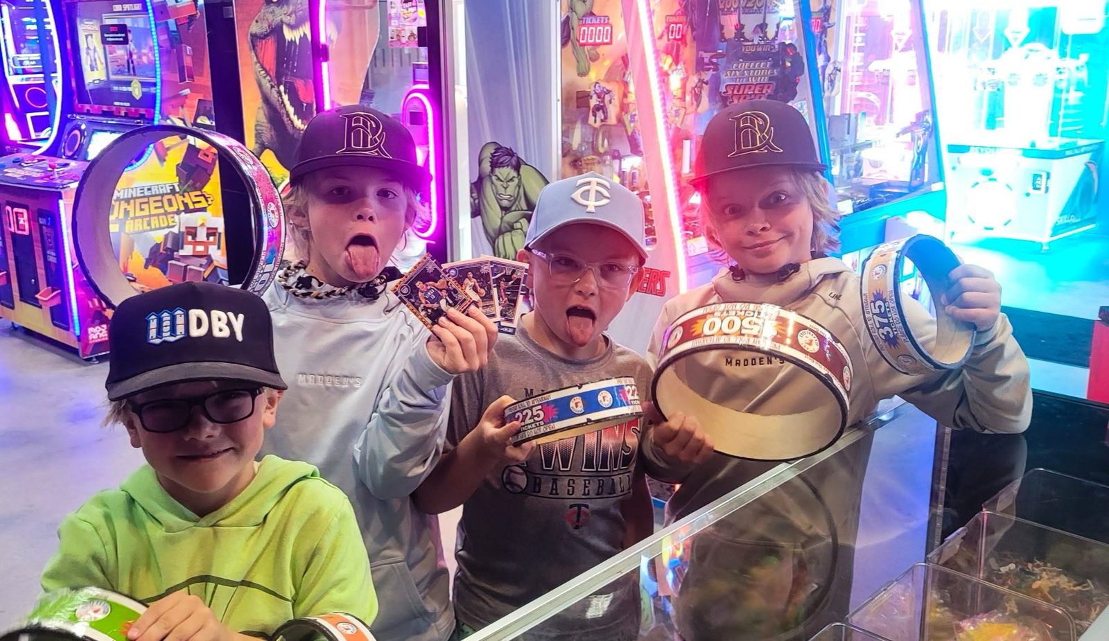 A group of kids in caps show off their ticket rings at the prize counter